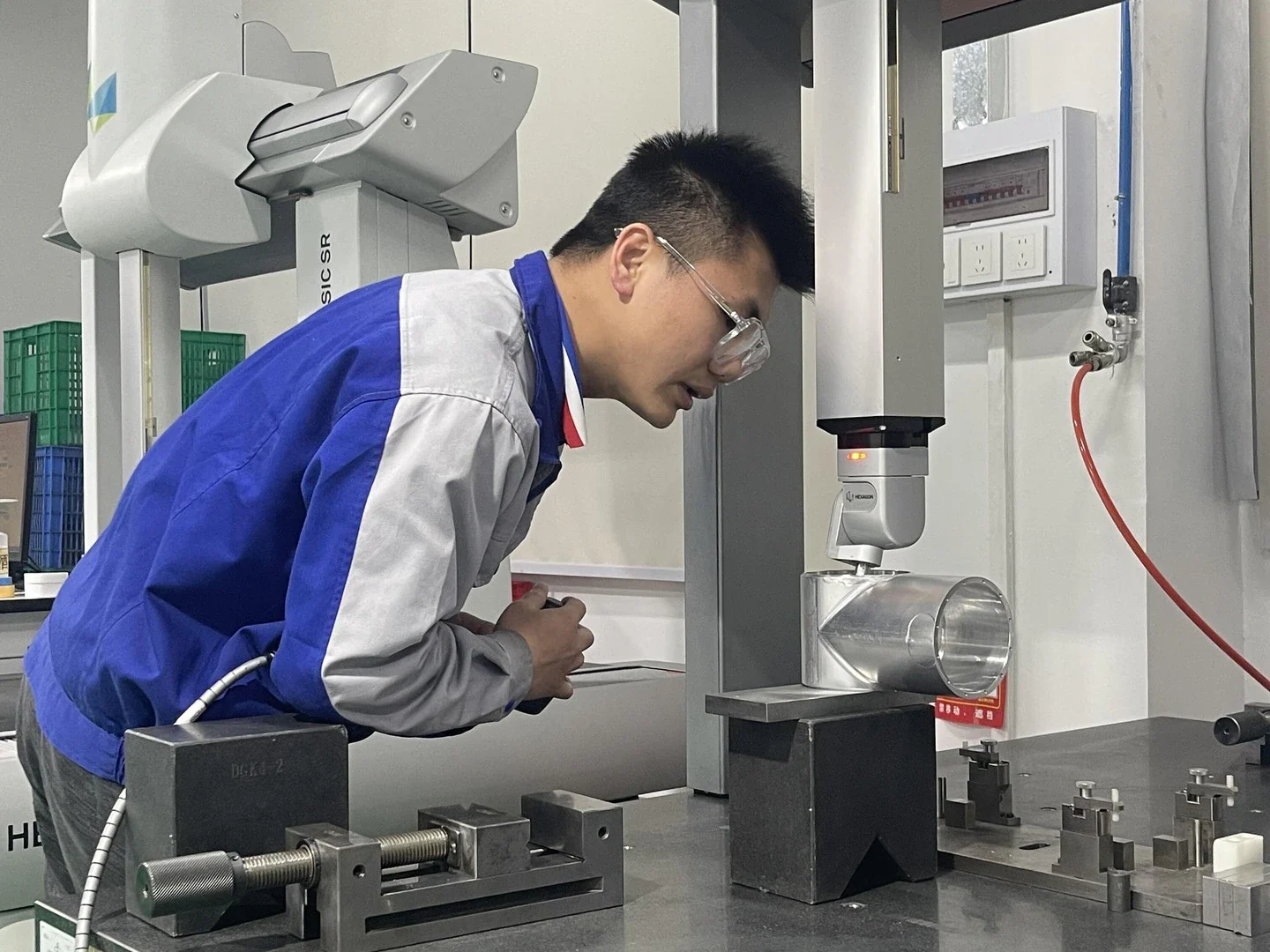 Technician inspecting a machined part on a coordinate measuring machine